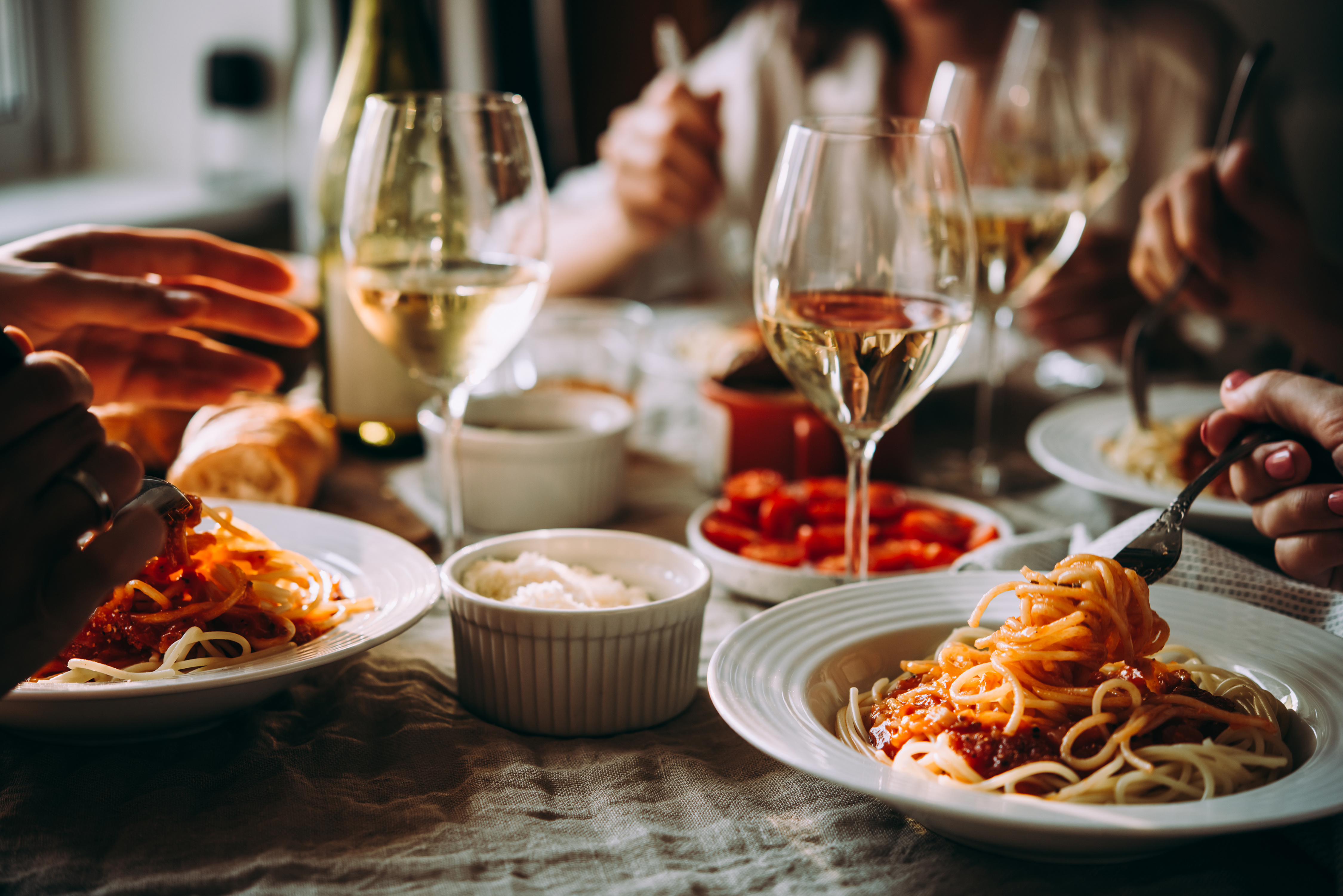 Friends sharing a pasta dinner at a table